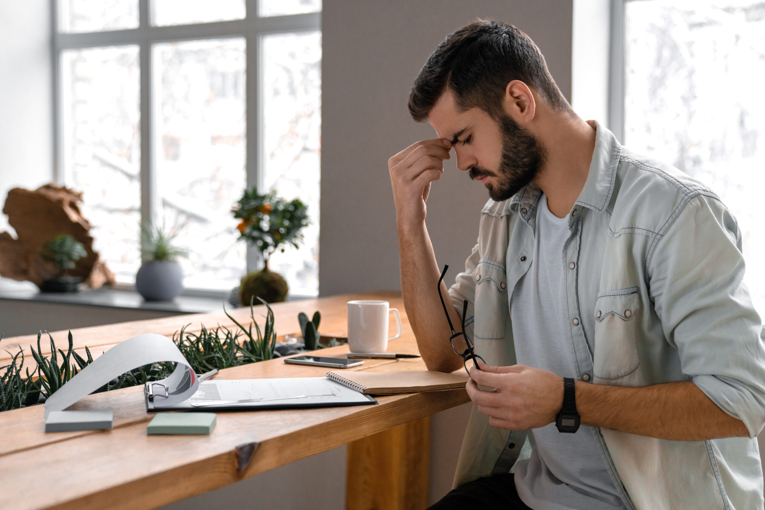 Male Businessman Concentrates On Documents In Office - Regulariza Portal